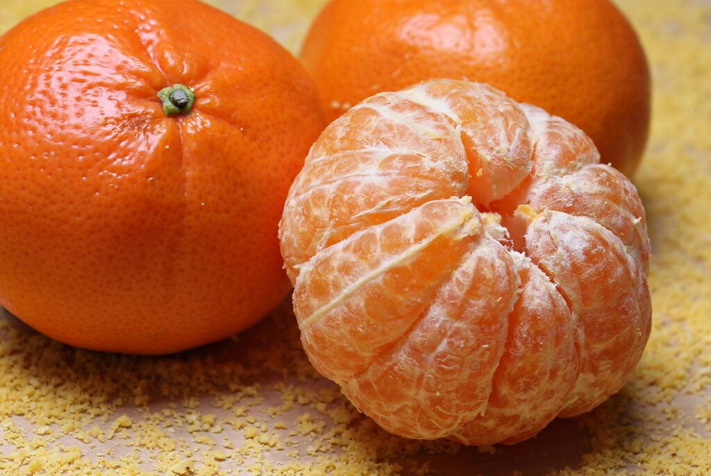 Home Close-up of fresh clementines and a peeled segment on a textured background.