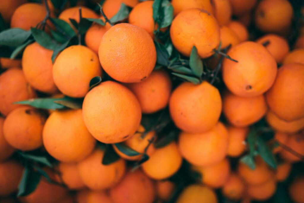 Pakistan Citrus Oranges for International Distribution A vibrant pile of fresh oranges with attached green leaves, emphasizing healthy eating.